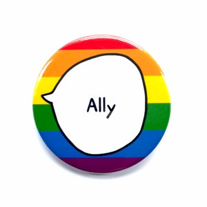 Puede incluir: Un botón redondo con un diseño de arcoíris y una burbuja de diálogo blanca que dice "Ally".