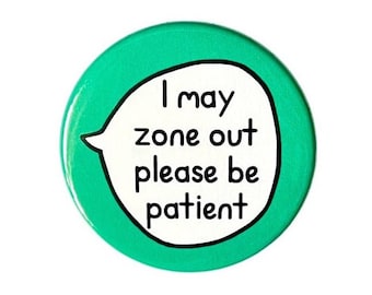 May include: A round, green button with the text "I may zone out please be patient" in a white speech bubble. The text is in black, bold, sans-serif font. The button has a glossy finish and a black border.