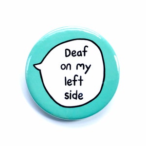 May include: A teal blue button with a white speech bubble that says "Deaf on my left side".
