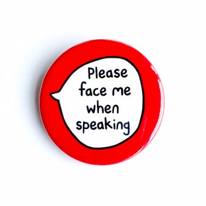 May include: Red round button with a white speech bubble that says "Please face me when speaking".