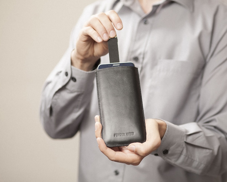 May include: A black leather phone case with a flap closure. The case has the text "Finger Welt" embossed on the front.
