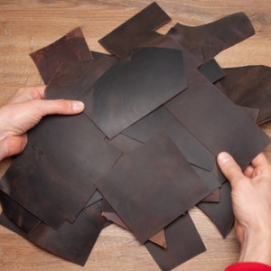 May include: A pile of brown leather scraps of various sizes and shapes.
