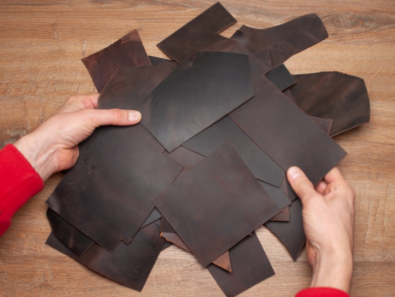 May include: A pile of brown leather scraps of various sizes and shapes.