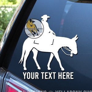 May include: White vinyl decal featuring a silhouette of a person riding a donkey, with the text "YOUR TEXT HERE" below. The decal also includes the text "YELLAPONY CUSTOMS" and a logo of a running horse.