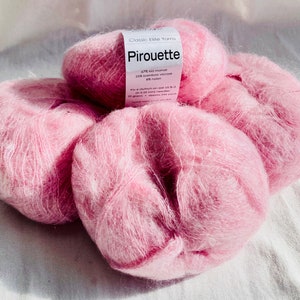 May include: Pink mohair yarn balls labeled "Classic Elite Yarns Piouette 47% kid mohair 20% bamboo viscose 33% nylon 40-inch stitch gauge US 8-3.25 mm needles 25 grams - approx 100 yards hand wash - lay flat to dry"
