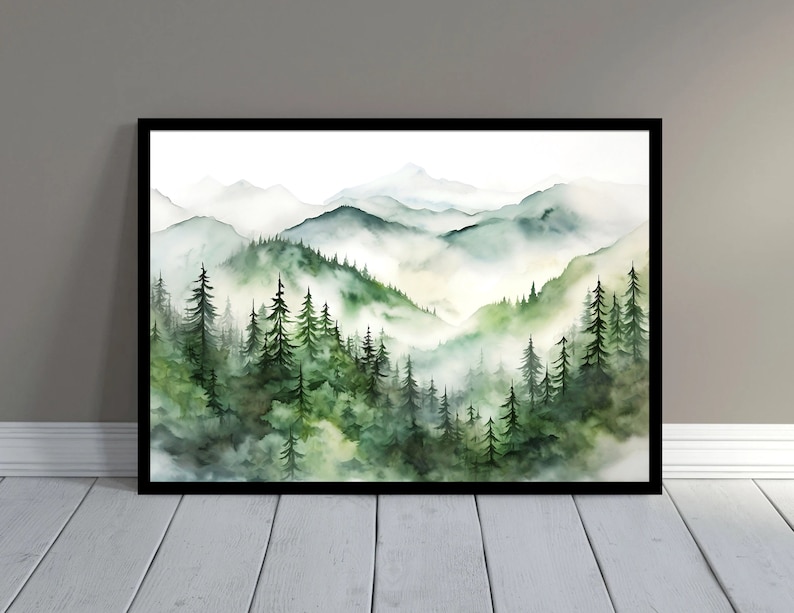 Puede incluir: Pintura a la acuarela de un paisaje monta&ntilde;oso con capas de &aacute;rboles verdes y picos brumosos. La obra de arte est&aacute; enmarcada en un borde negro, creando una est&eacute;tica serena y natural. La paleta de colores incluye tonos de verde, blanco y gris.