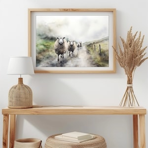 May include: A watercolor painting of a group of sheep walking down a path in a foggy landscape. The sheep are white with brown markings and are walking in a line. The path is dirt and the landscape is green and brown.
