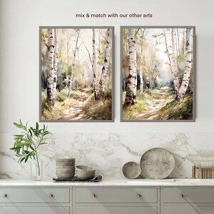May include: Two framed watercolor paintings of a birch tree forest path. The paintings are in muted tones of brown, green, and white. The text "mix & match with our other arts" is above the paintings.
