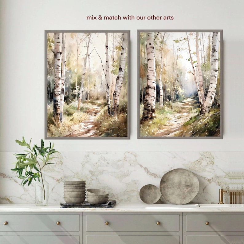 May include: Two framed watercolor paintings of a birch tree forest path. The paintings are in muted tones of brown, green, and white. The text "mix & match with our other arts" is above the paintings.