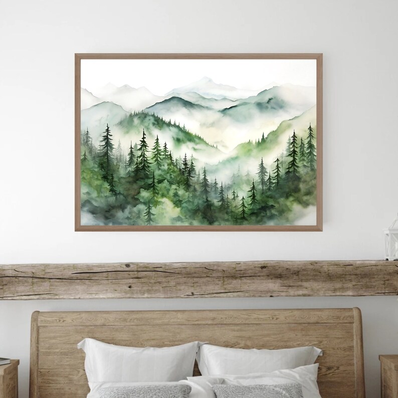 Puede incluir: Una pintura de acuarela enmarcada de un paisaje de monta&ntilde;a. La obra de arte representa capas de &aacute;rboles verdes y monta&ntilde;as brumosas en tonos verdes y azules. La pintura est&aacute; en un marco de madera marr&oacute;n.
