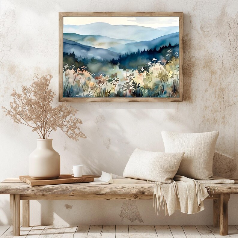May include: A watercolor painting of a mountain landscape with a blue and green color scheme. The painting depicts a forest in the foreground with a mountain range in the background. The painting is framed in a wooden frame.