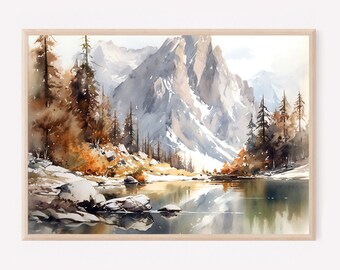 May include: A framed watercolor painting depicting a mountain landscape with snow-capped peaks, a calm lake reflecting the scenery, and surrounding evergreen trees in shades of brown, orange, and green, set within a light-colored wooden frame.