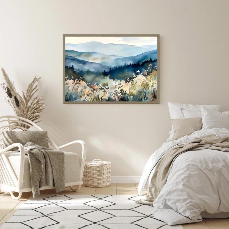 May include: A watercolor painting of a mountain landscape with blue and green hues. The painting depicts a misty mountain range with trees and wildflowers in the foreground.