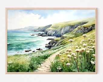 May include: Watercolor painting of a coastal landscape with a path leading to the ocean. The artwork features a light blue sky, green cliffs, and turquoise water. White wildflowers line the path, and the artwork is framed in a light wood frame.