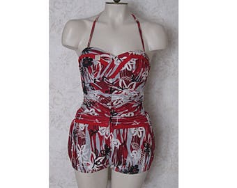 May include: A red and white floral print swimsuit with a halter top and a short skirt. The swimsuit has a gathered waist and a ruffled hem.
