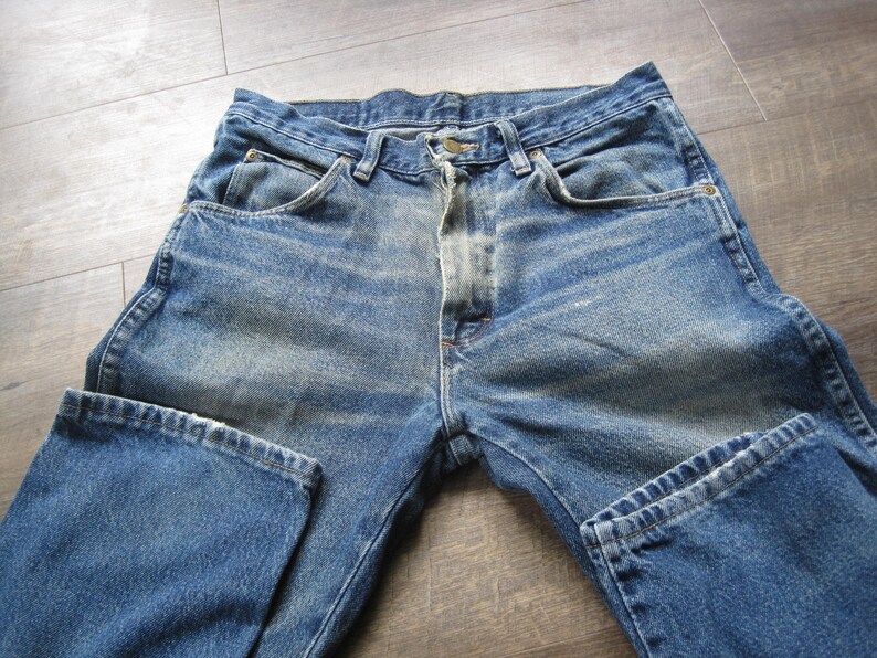 May include: A pair of blue denim jeans with a faded wash and a classic five-pocket style.