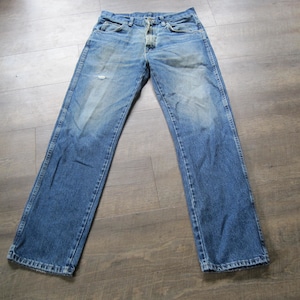 May include: A pair of blue denim jeans with a button fly and a faded look. The jeans have a straight leg and are made of a soft, comfortable fabric.
