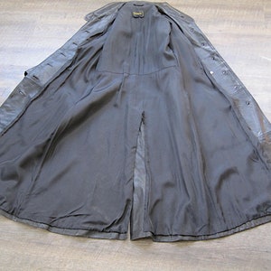 May include: A black leather trench coat with a center back vent and a button closure. The coat is fully lined and has a smooth, silky feel.