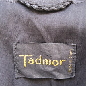 May include: A black leather label with gold stitching that reads "Tadmor" and "MADE IN ISRAEL".