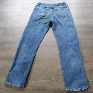 May include: A pair of blue denim jeans with a red label on the back pocket.