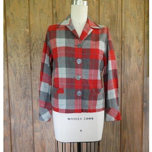 May include: A red, gray, and light blue plaid jacket with a collar and three buttons. The jacket has two front pockets and is displayed on a mannequin. The mannequin has the text "MODEL 2008" and the size "S".