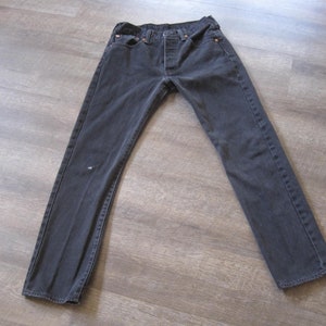 May include: A pair of dark gray denim jeans with a classic five-pocket style.