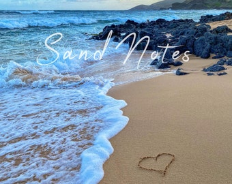 Maui donation to their humane soc with purchase, heart in sand, Oahu beach, vibrant blue sky, queen's beach, white foam.