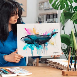 May include: A watercolor painting of a whale with a colorful background. The whale is painted in shades of blue and black, and the background is a mix of pink, yellow, and blue.