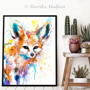 Puede incluir: Pintura acuarela de un zorro fennec con orejas grandes. El zorro est&aacute; pintado en tonos de naranja, amarillo, azul y morado. El fondo es blanco con salpicaduras de amarillo y azul.