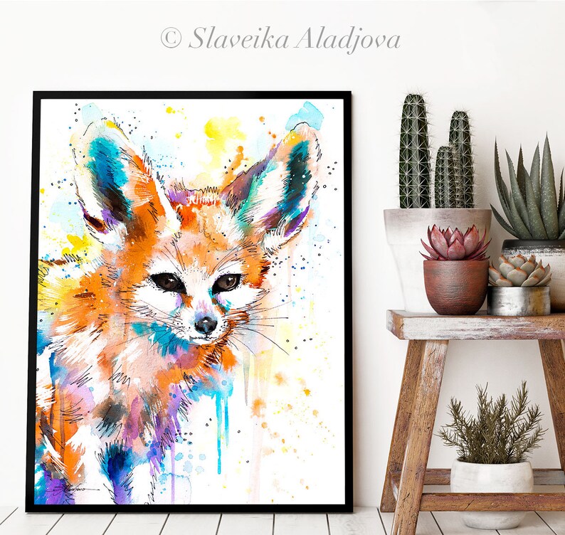 Puede incluir: Pintura acuarela de un zorro fennec con orejas grandes. El zorro est&aacute; pintado en tonos de naranja, amarillo, azul y morado. El fondo es blanco con salpicaduras de amarillo y azul.