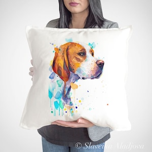 May include: A white pillow with a watercolor painting of a brown and white dog's head. The dog is looking to the right and has a splash of blue, green, and yellow paint behind it.