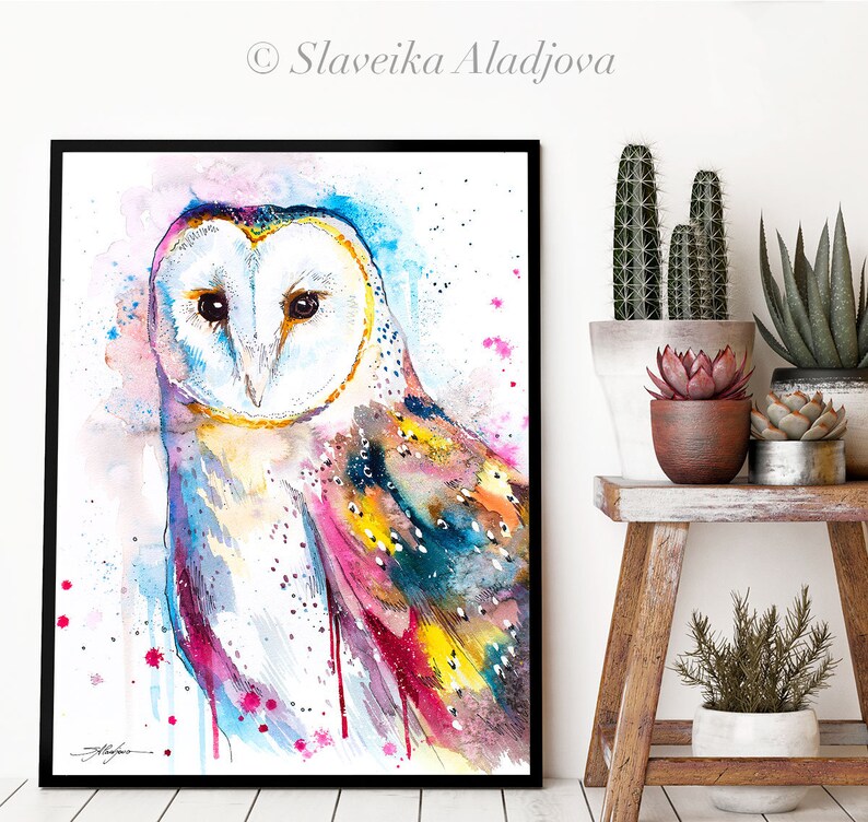 May include: Watercolor painting of a barn owl with colorful feathers. The owl's face is white with black eyes and a yellow beak. The background is a light blue with pink and yellow splatters.