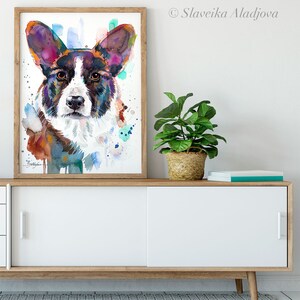 Op de afbeelding: Waterverf schilderij van een Cardigan Welsh Corgi hond met bruine, witte en paarse vacht. De hond kijkt recht naar de kijker. De achtergrond is lichtblauw met spatten van kleur.