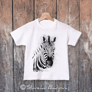 May include: White t-shirt featuring a black and white watercolour illustration of a zebra's head. The zebra is looking directly at the viewer.