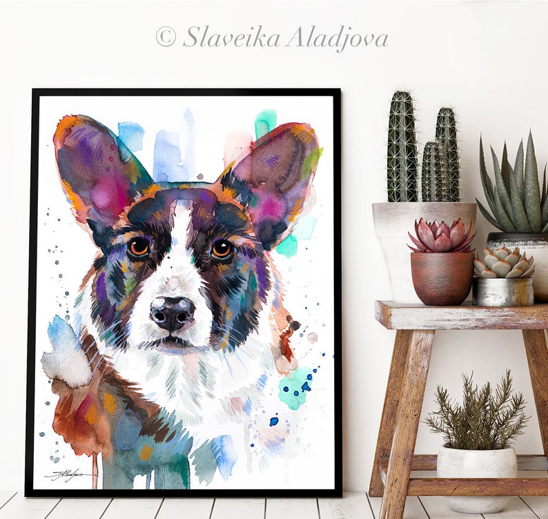 Op de afbeelding: Waterverf schilderij van een Cardigan Welsh Corgi hond met een witte achtergrond. De vacht van de hond is geschilderd in tinten van bruin, zwart en wit, met spatten van paarse, blauwe en groene waterverf.