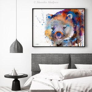 May include: Watercolor painting of a wombat with blue, orange, and purple hues. The wombat is looking directly at the viewer with a curious expression. The background is white with splatters of paint.