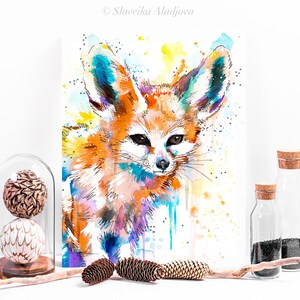 Puede incluir: Pintura acuarela de un zorro fennec con grandes orejas. El zorro est&aacute; pintado en tonos de naranja, amarillo, azul y morado. El fondo es de color amarillo claro con salpicaduras de color.