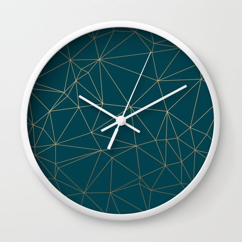 May include: A white clock with a teal blue face and gold geometric lines. The clock hands are white.