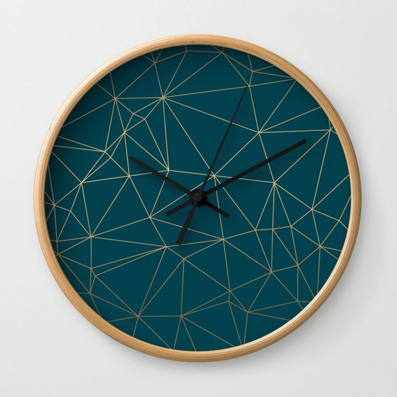 May include: A teal blue clock with a gold geometric pattern and black hands.