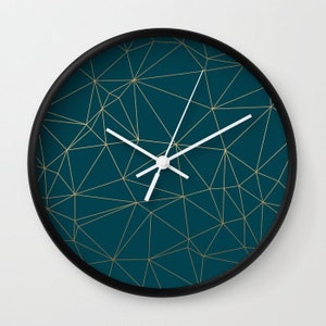 May include: A teal blue clock with a black frame and gold geometric lines. The clock hands are white.