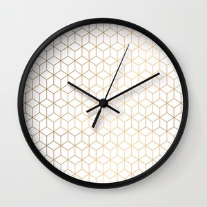 May include: A black and white clock with gold geometric pattern on the face. The clock has black hands and a black frame.