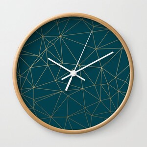 May include: A teal blue clock with a gold geometric pattern and white hands.