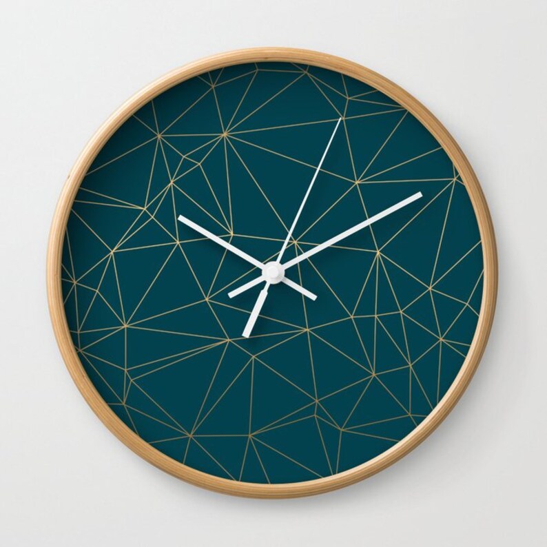 May include: A teal blue clock with a gold geometric pattern and white hands.
