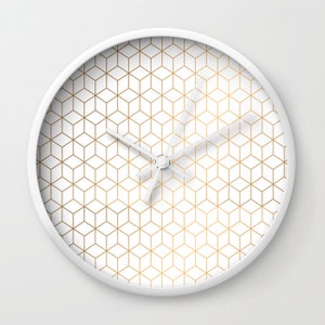 May include: White wall clock with a gold geometric pattern. The clock has a white face and gold hands.