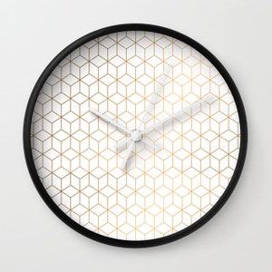 May include: A black framed clock with a white face and gold geometric pattern.
