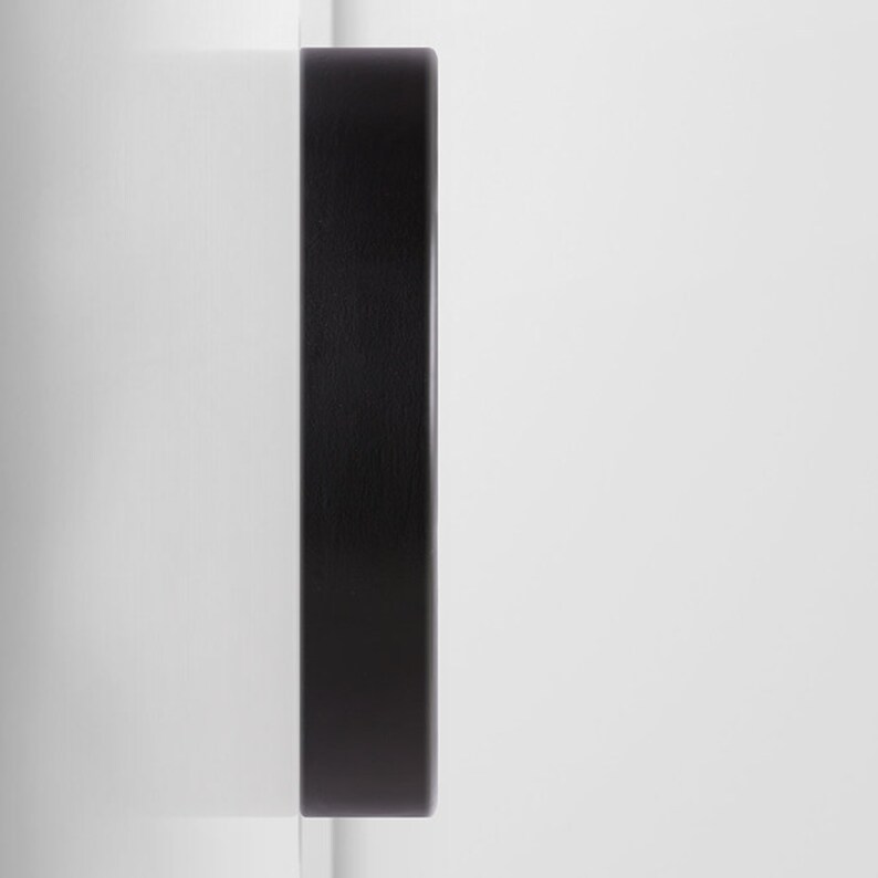 Pu&ograve; includere: Un quadrante di orologio in legno nero con sfondo bianco.
