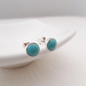 May include: A pair of silver stud earrings with turquoise stones.