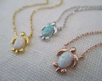 Può includere: Tre collane di tartaruga d'argento con pietre di opale. Le tartarughe sono in oro, argento e oro rosa.