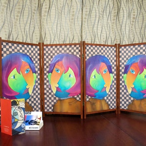 May include: A four-panel room divider screen with a checkered pattern and colorful abstract faces painted on each panel. The screen is made of wood and fabric.
