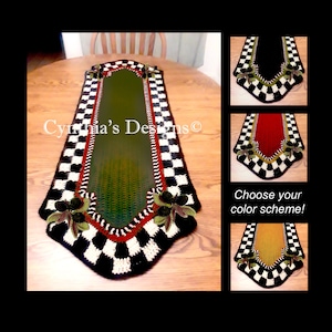 May include: A handmade table runner with a green center, framed by a black and white checkered pattern. The runner features decorative floral accents and a red border. The text "Cynthia's Designs" is visible.